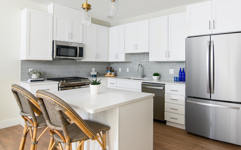 Spacious and well lit kitchen with wood floors and granite counters 